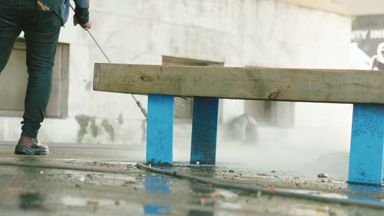 Technician pressure washing a sidewalk